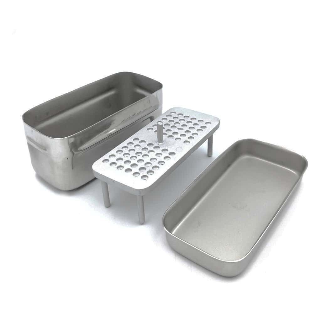 Stainless steel dental instrument tray with additional accessories for dental procedures.